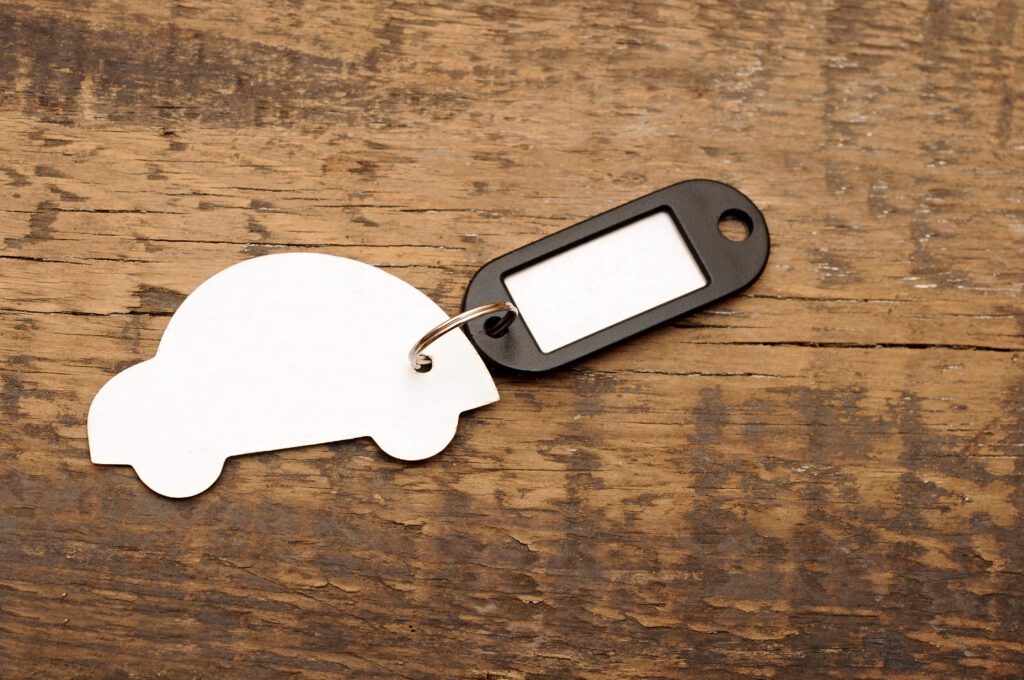 model car with blank tag on wooden background acquiring auto insurance