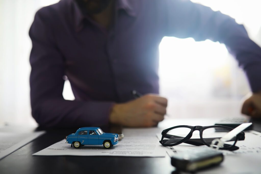The insurance agent signs a document. Car insurance policy. Auto insurance policy. Forms registration of the contract.