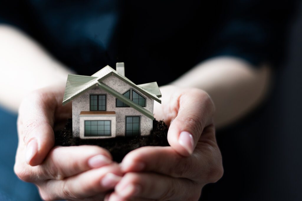 Hands holding a toy house with owners asking for a homeowners insurance quote