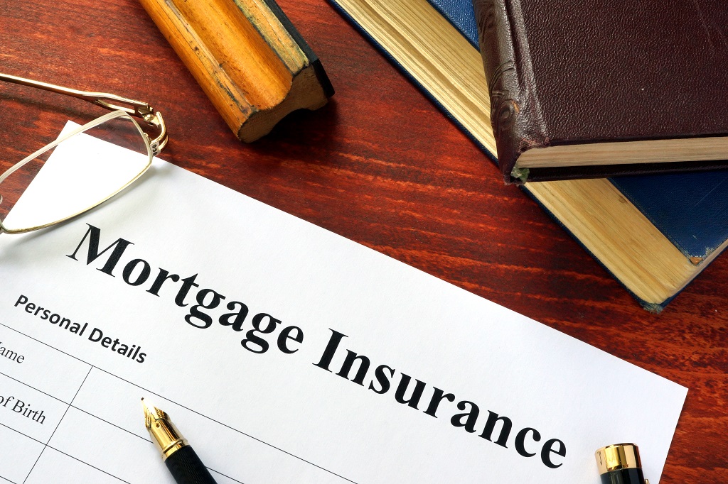 Mortgage insurance policy with a book and a pen.