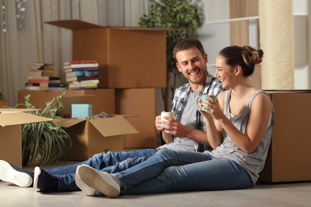 Happy couple sitting on the floor a¿in their new home after knowing How Much is Renters Insurance in PA